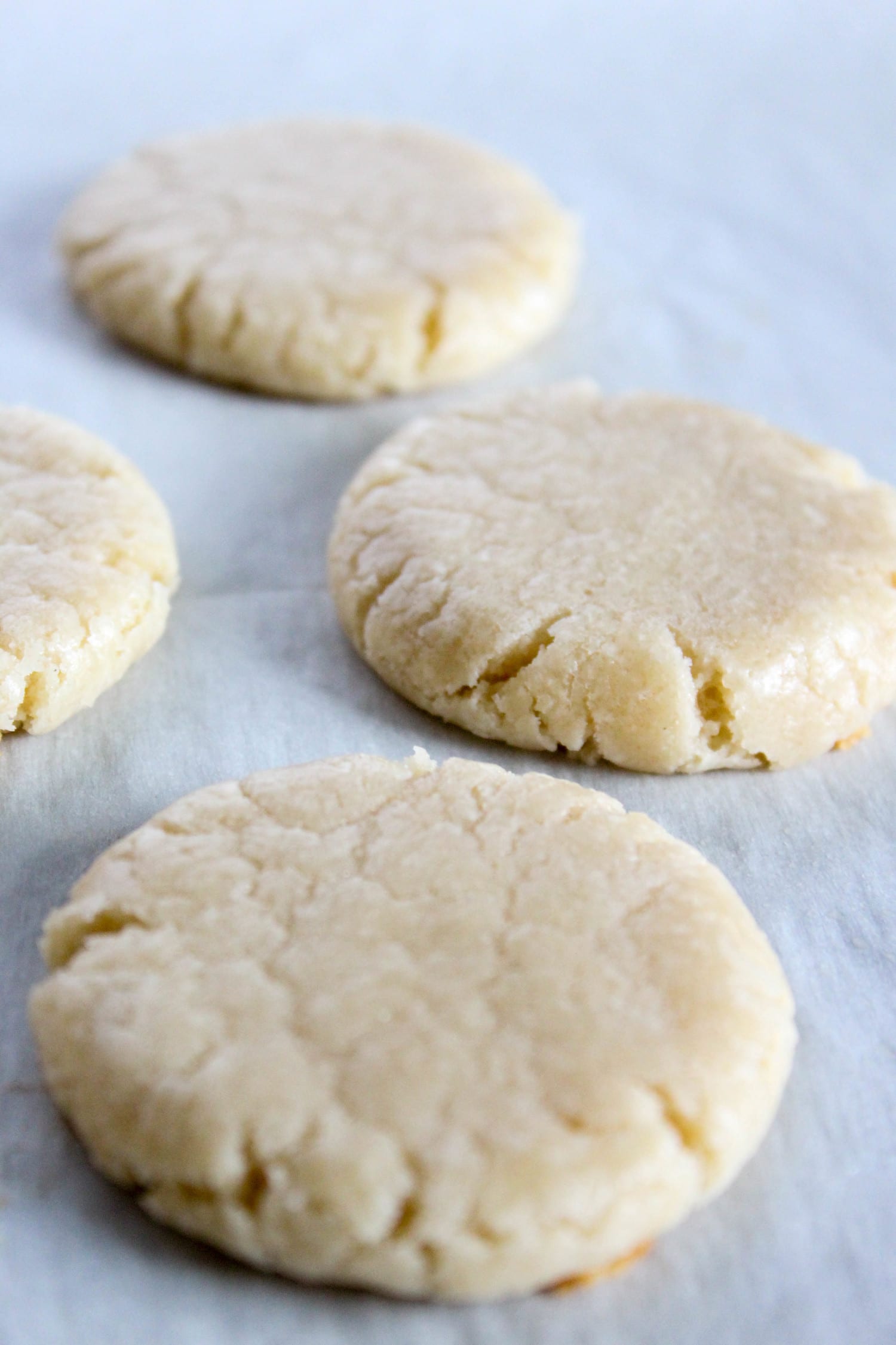 four almond shortbread cookies cooling on a baking sheet