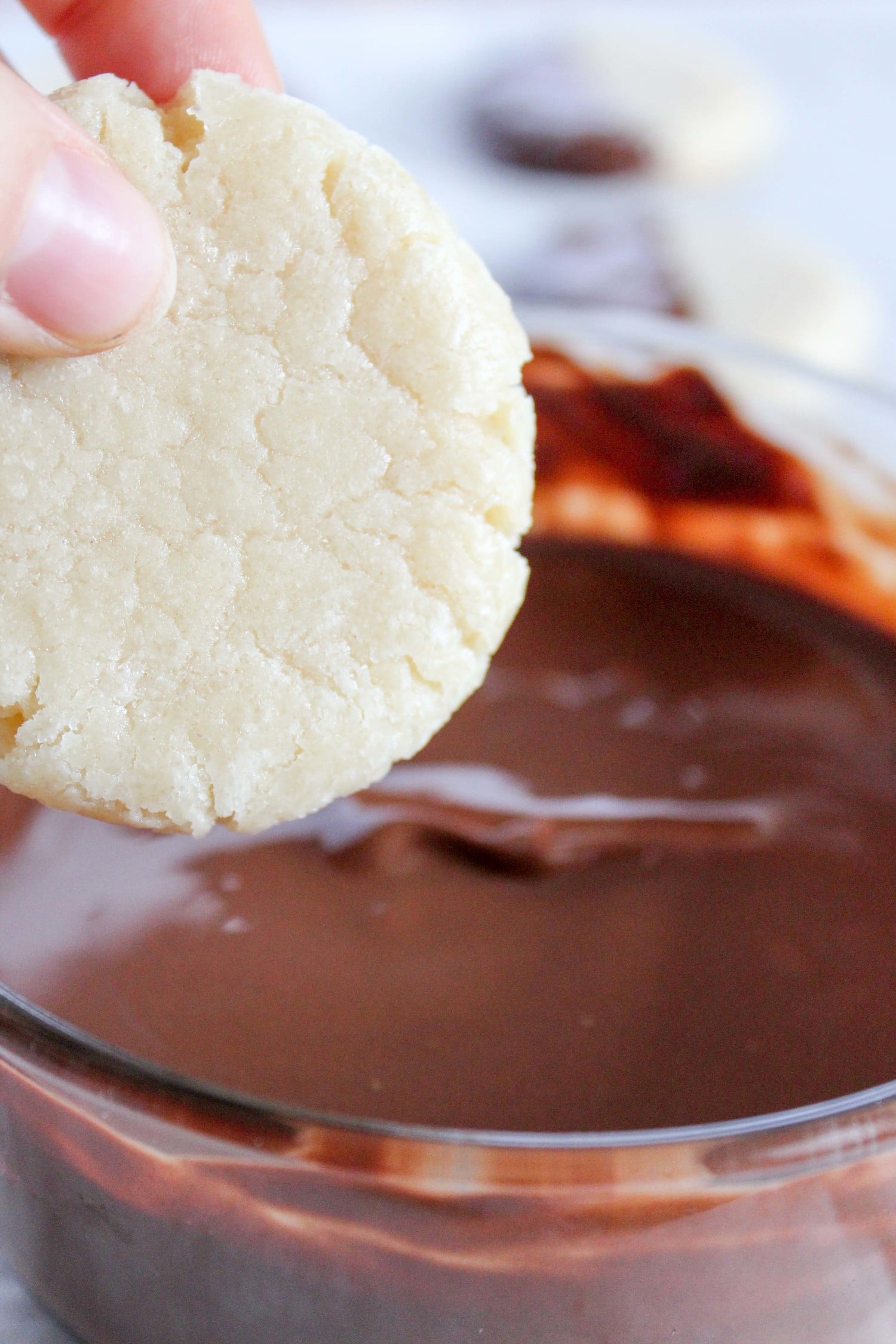dipping an almond shortbread cookie into melted chocolate