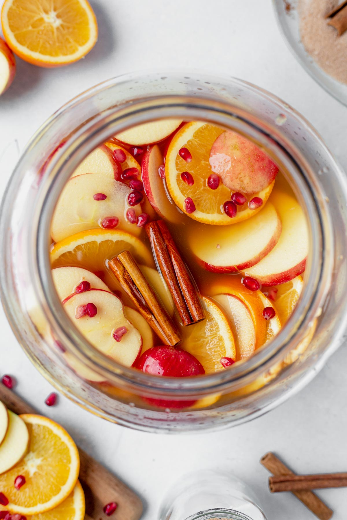 apple cider sangria in a large pitcher with cinnamon sticks