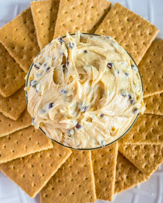 aerial view of buckeye dip and chocolate chips in a bowl with graham crackers fanned around the bottom