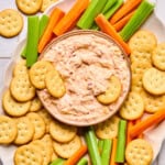 pimento cheese dip in a bowl surrounded by Ritz crackers and carrot and celery sticks
