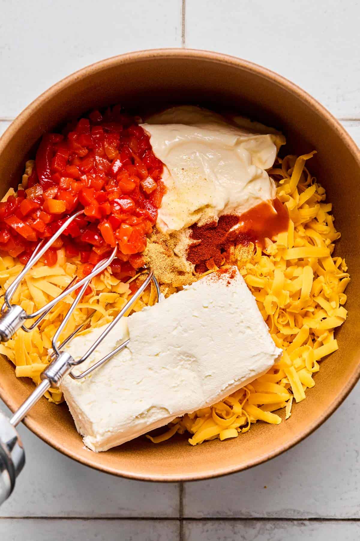 ingredients for pimento cheese dip added to a bowl ready to be mixed with hand mixer.
