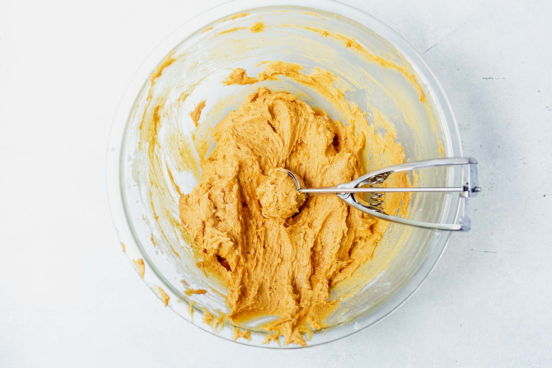 pumpkin cookie dough in a bowl with a cook scoop
