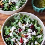 kale goat cheese salad in a salad bowl on a wooden table