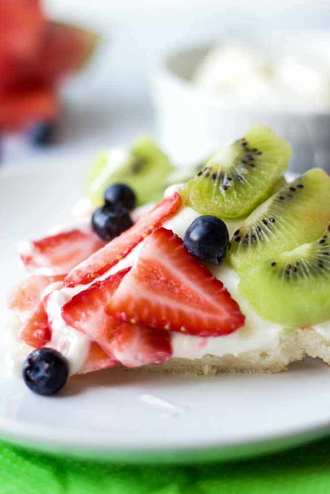 Summer Fruit Pizza featuring a chewy sugar cookie, sweet and tangy cream cheese frosting and fresh summer fruit including strawberries, kiwi and blueberries. 
