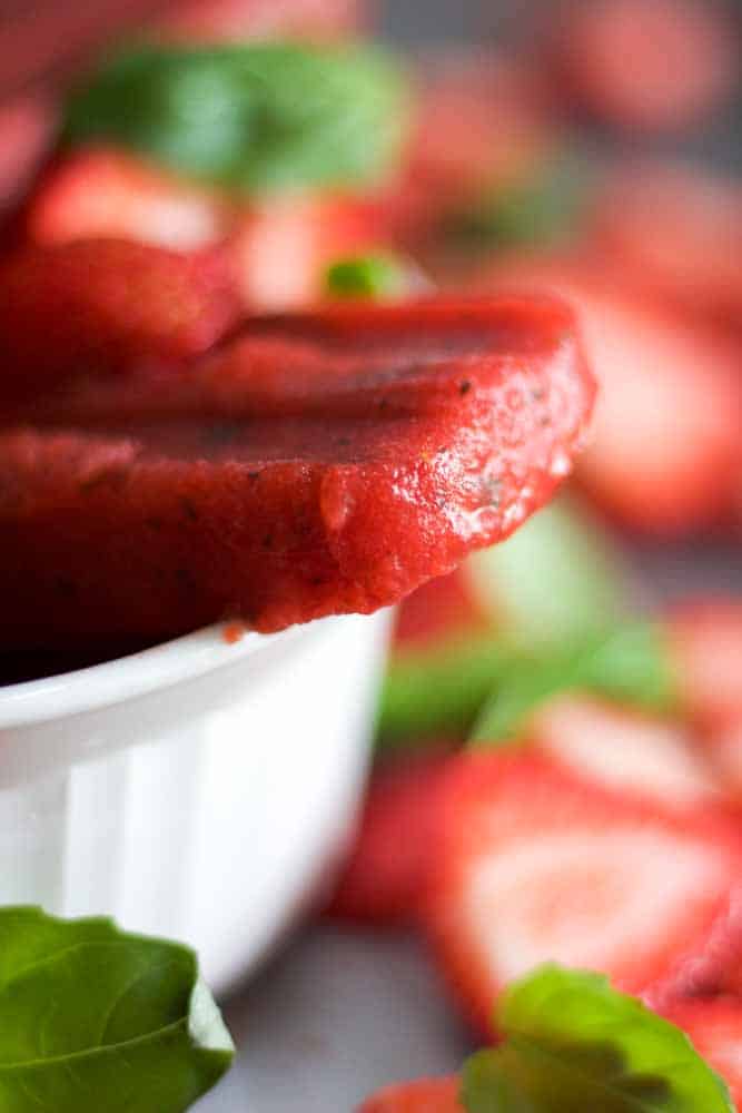 Paleo and healthy three ingredient strawberry basil popsicles! This recipe is easy to make and made with real strawberries, basil and honey. Blend them in your blender and pour in popsicles molds. Freeze for a couple of hours and you have a vegan, paleo and gluten free dessert recipe.