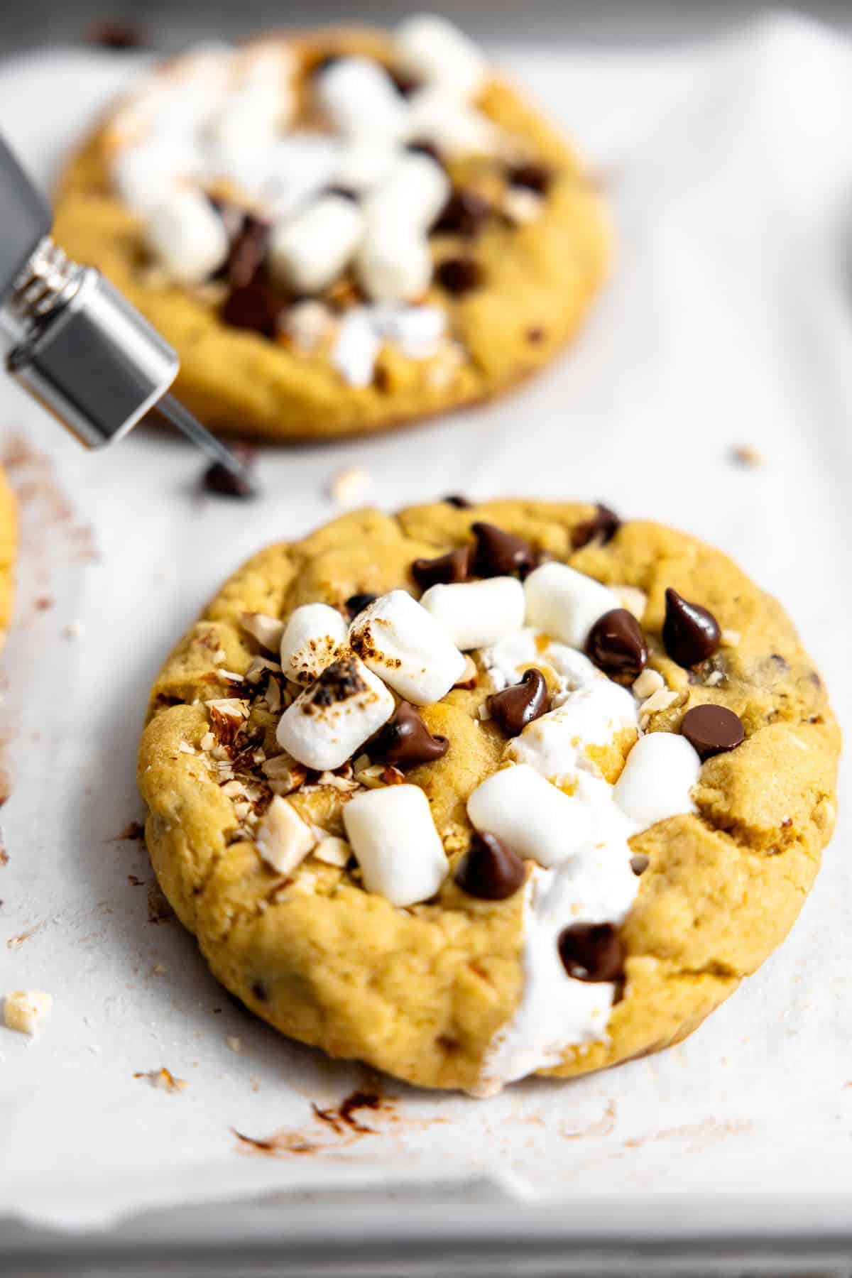 toasting marshmallows on top of rocky road cookies with a kitchen torch