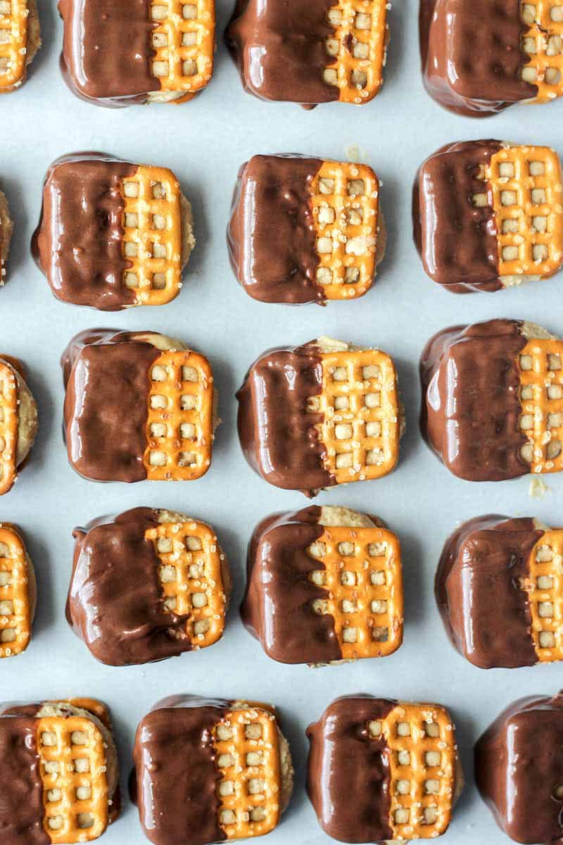 Easy, no bake buckeye bites! These bite sized desserts are filled with peanut butter "buckeye" filled, sandwiched between two pretzels and dipped in chocolate. Everyone goes crazy over this recipe! This candy like dessert will impress everyone.