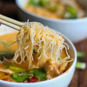 chopsticks reaching into a bowl of thai curry pho