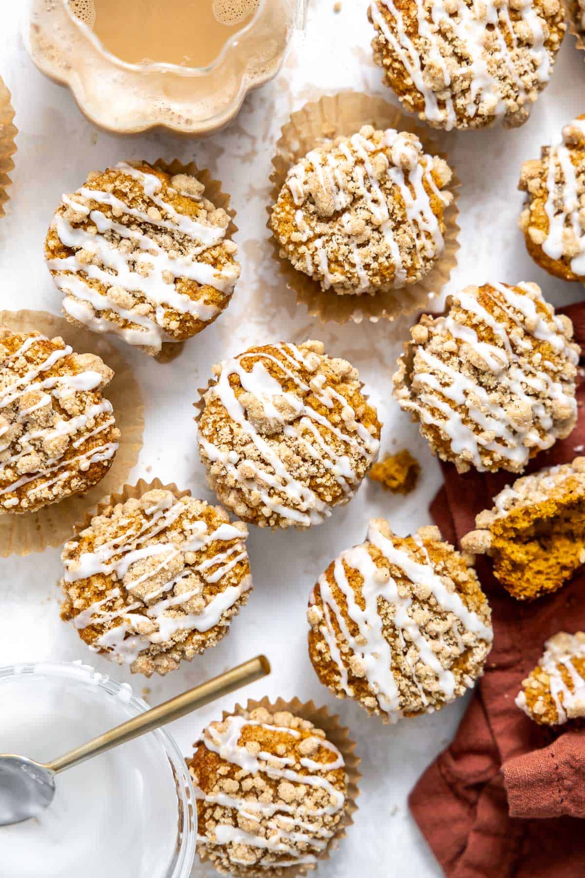 a batch of pumpkin streusel muffins on a countertop.