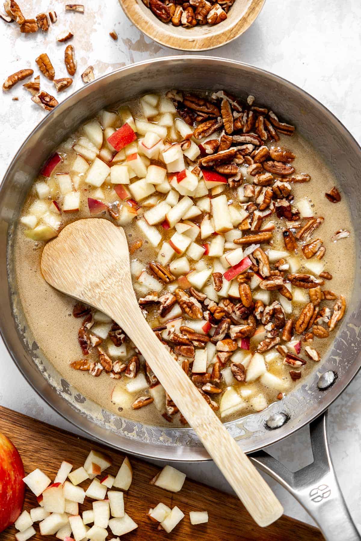 melted butter and brown sugar in a saucepan with pecans and apples.