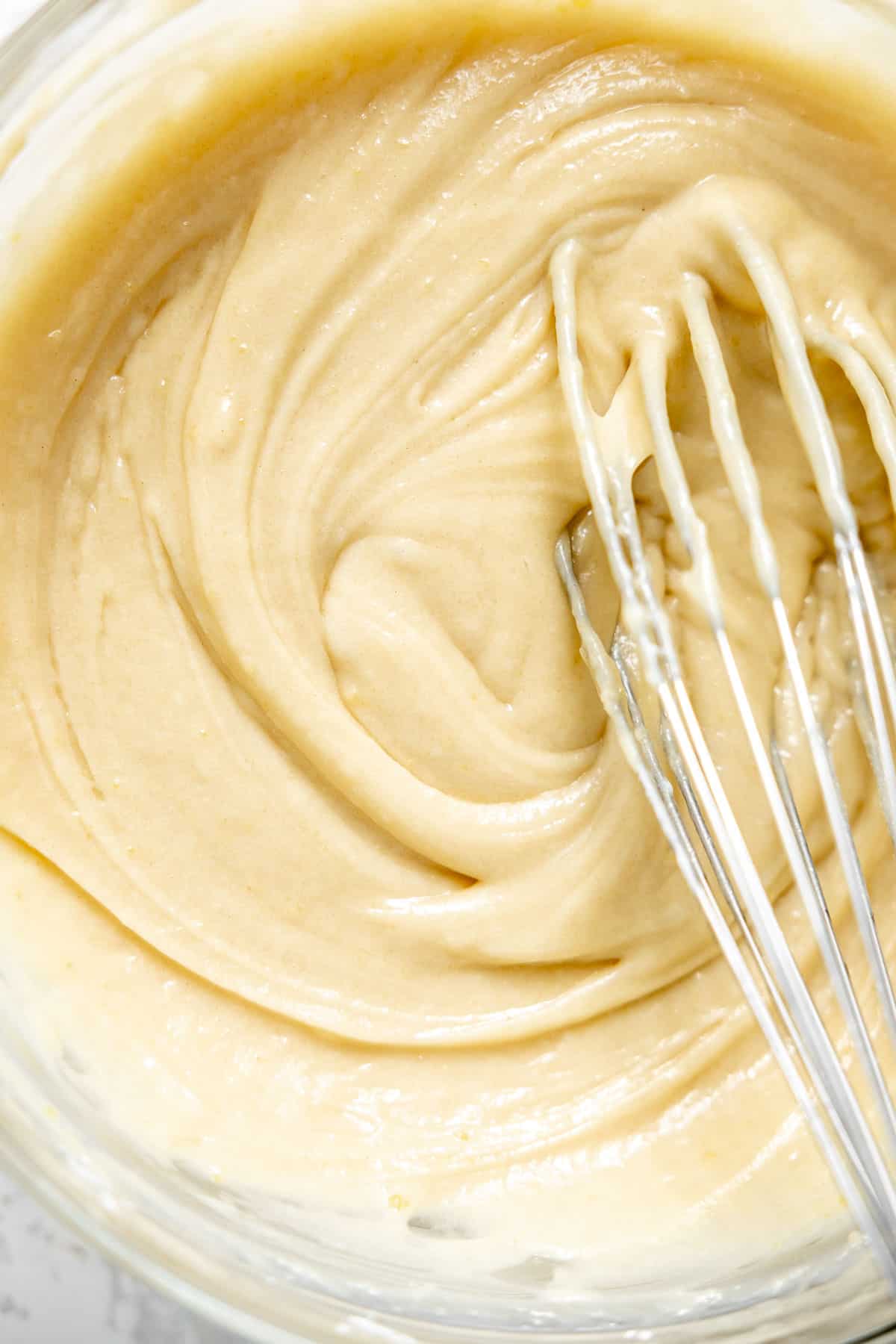 stirring vanilla cake batter in a mixing bowl.