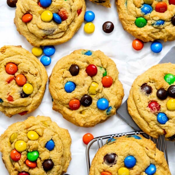 M&M pudding cookies cooling on parchment paper