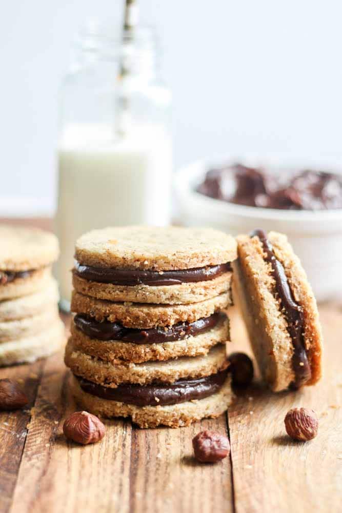 Buttery and filled with chocolate, this Hazelnut Shortbread cookie recipe is the perfect sandwich cookie for Christmas. Nutella desserts are the best and these cookies are filled with Nutella ganache. The hazelnut shortbread is nutty and perfect. Your friends and family (even the kids) will love them!