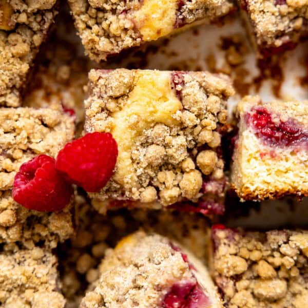raspberry coffee cake cut into squares on parchment paper