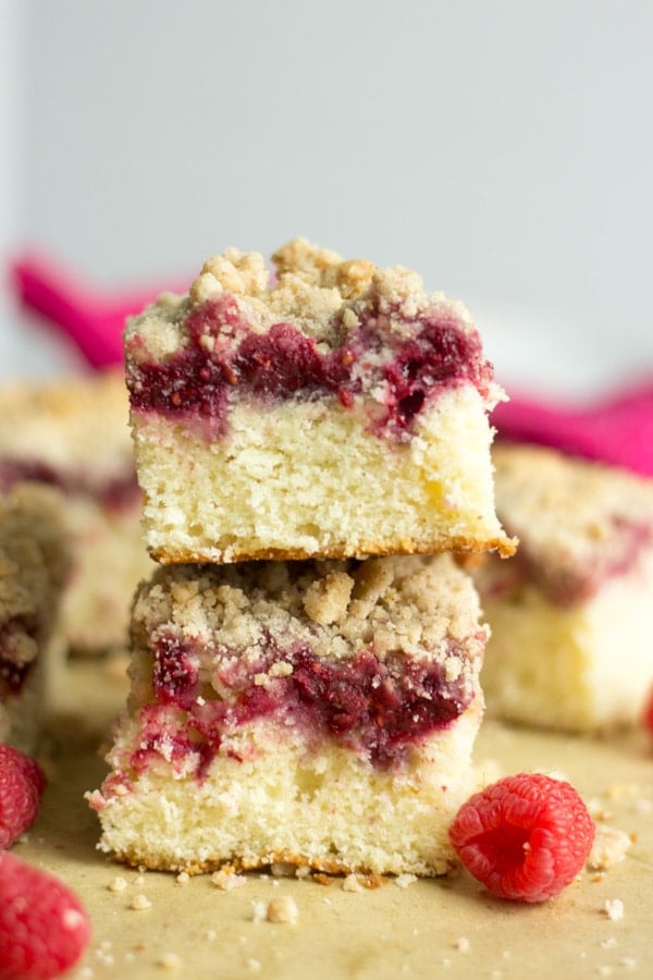 two pieces of raspberry coffee cake stacked on top of each other so you can see the raspberry filling