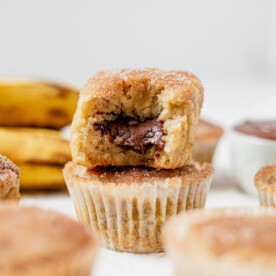 two banana nutella muffins stacked on top of each other so you can see the nutella melting out of the middle