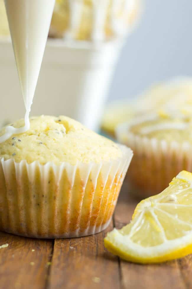 bag of icing being squeezed onto healthier lemon poppy seed muffins