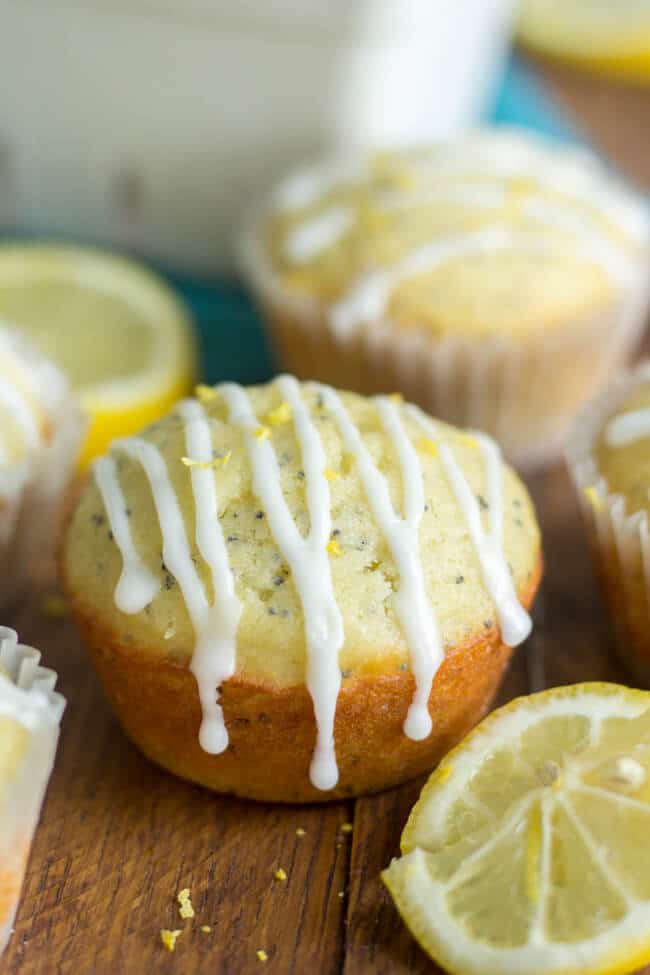 healthy lemon poppy seed muffins with lemon glaze, lemon zest and sliced lemons