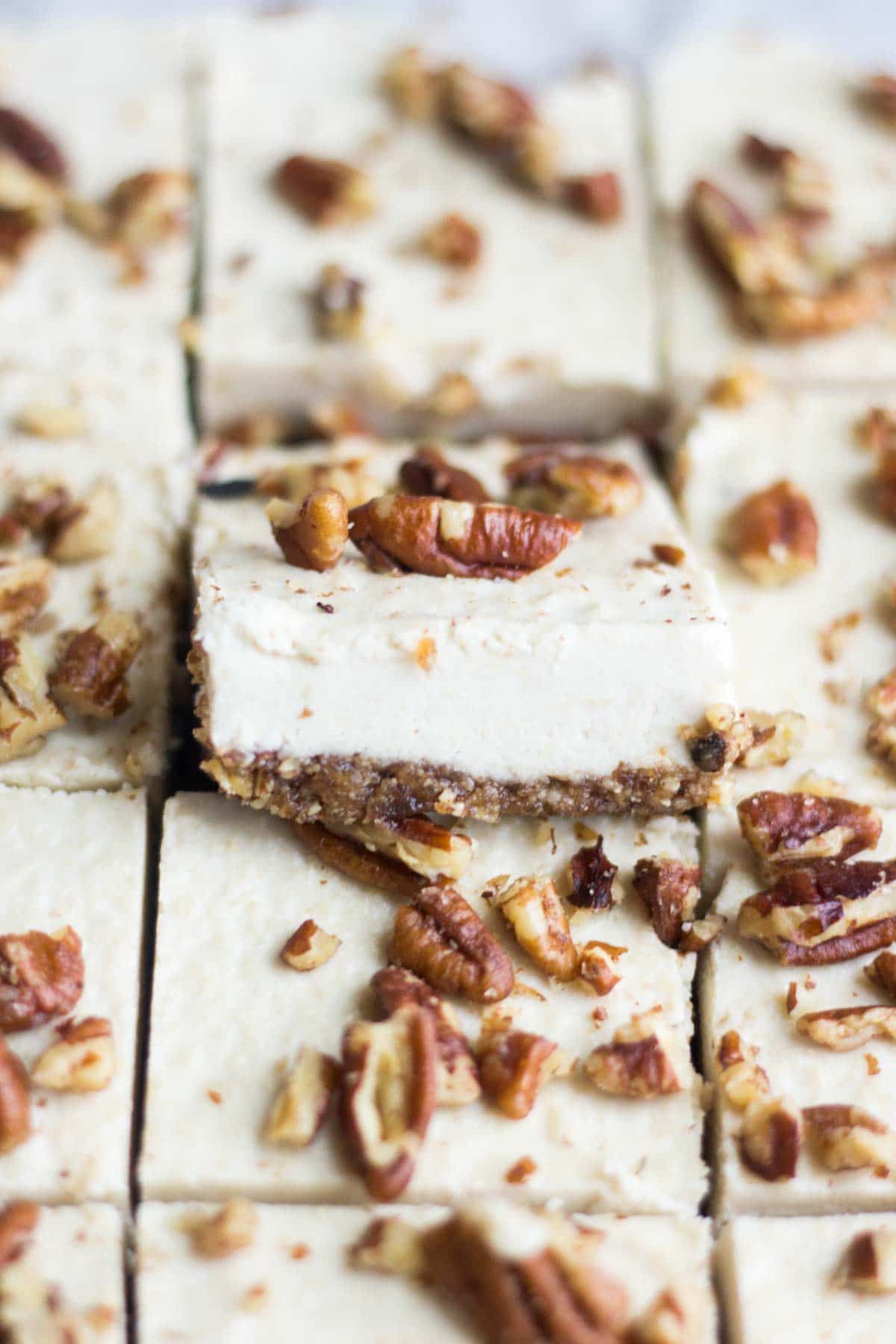 Smooth and creamy, these turtle vegan cheesecake bars are an easy and no bake healthy dessert. The crust is made with pecans and dates and the silky vegan cheesecake is topped with paleo caramel and pecans. You won't believe how yummy an easy it is to make!