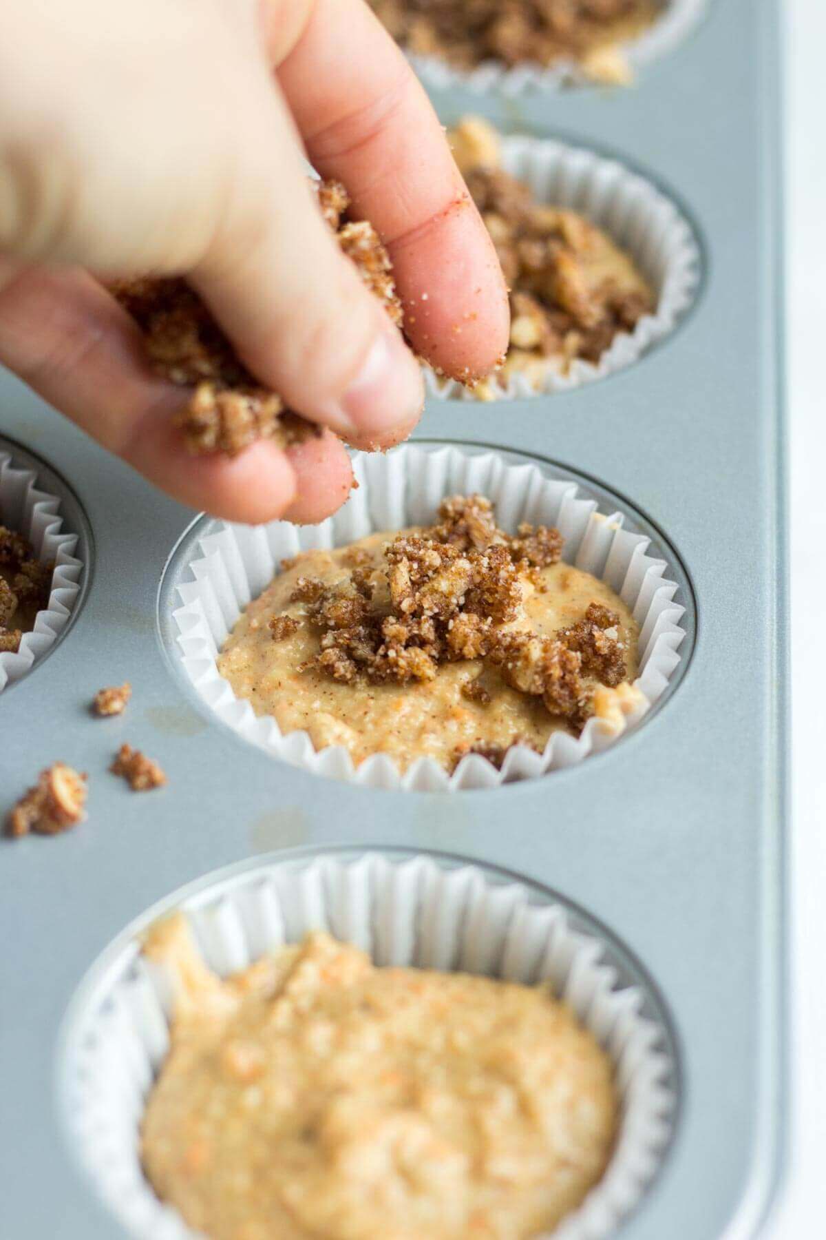 The best Easter recipe, these paleo cinnamon streusel carrot muffins have a layer of pecan and cinnamon topping piled on top. The carrot muffin base is filled with carrots and more cinnamon and sweetened with ripe bananas. This recipe is so moist and flavorful! You're friends and family won't even know it's paleo and gluten-free on Easter morning!