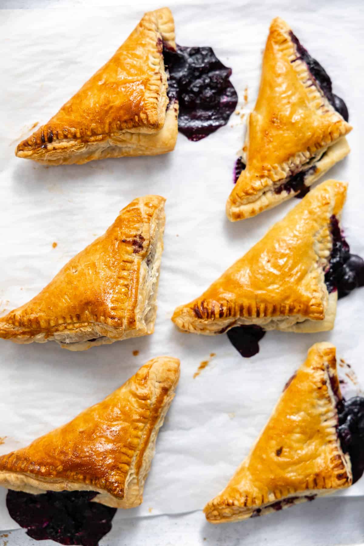 fresh baked blueberry turnovers on a sheet pan