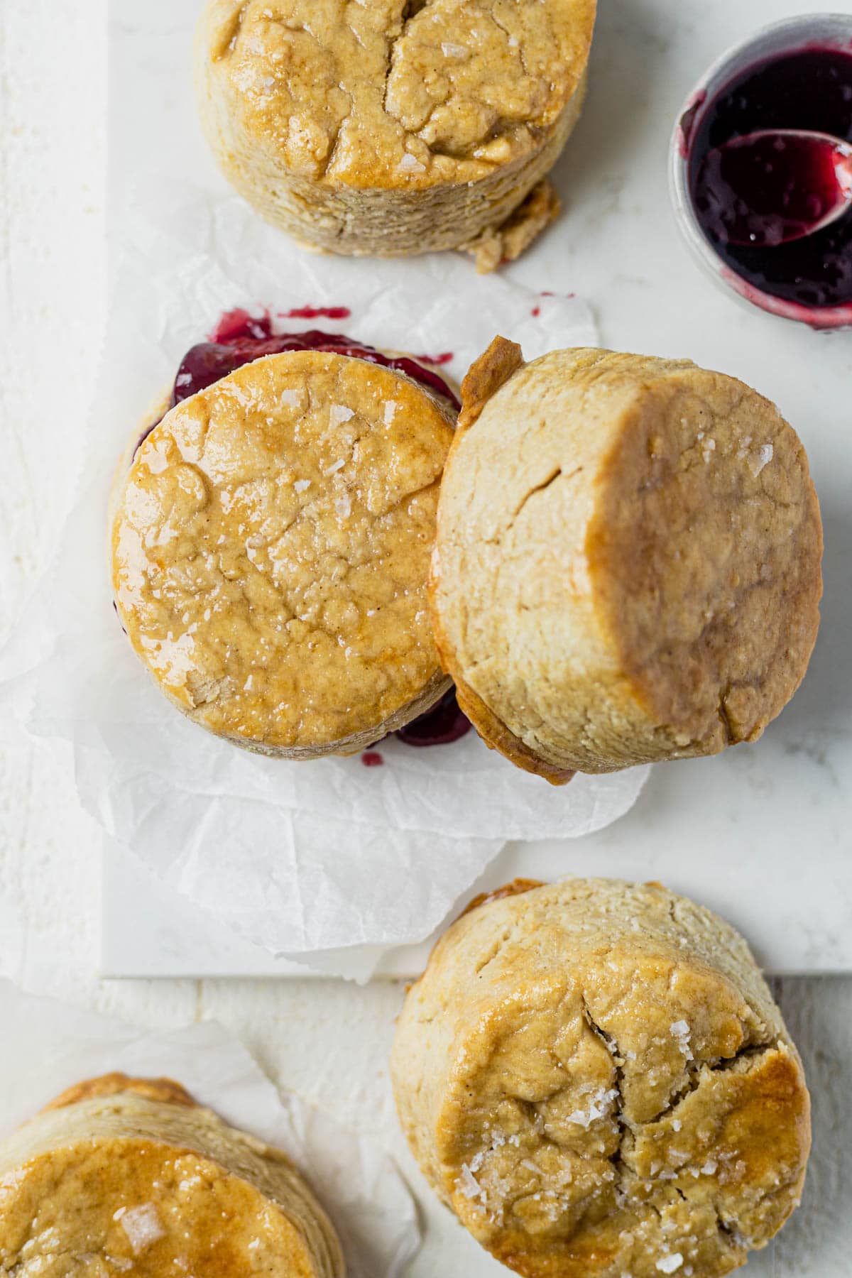 top down view of 5 vegan biscuits with a bowl of jam on the side