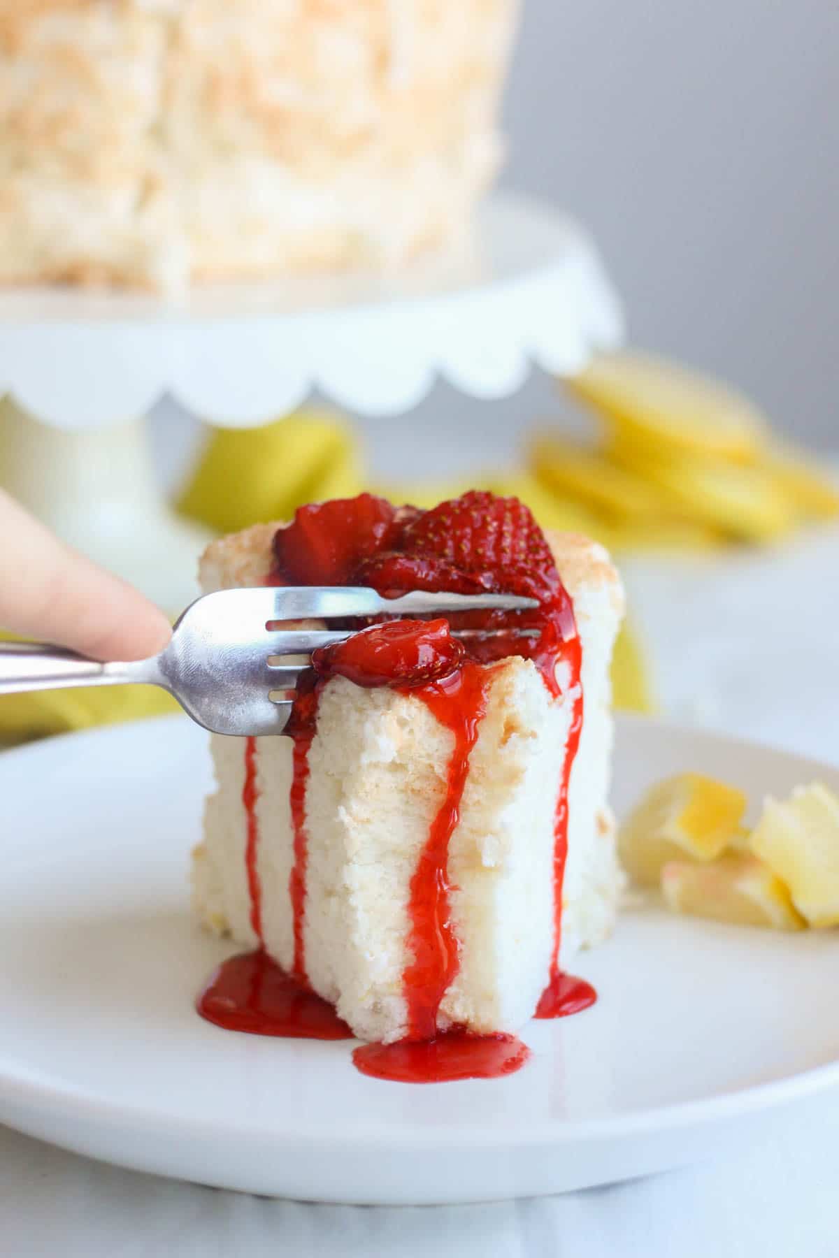 Light and fluffy, this lemon angel food cake melts in your mouth and packs a powerful citrus punch. Made with fluffy egg whites and lots of lemon zest, this cake recipe will be your new go-to for spring and summer entertaining. Serve it with strawberry compote on top for a bright bite of fruity flavor.