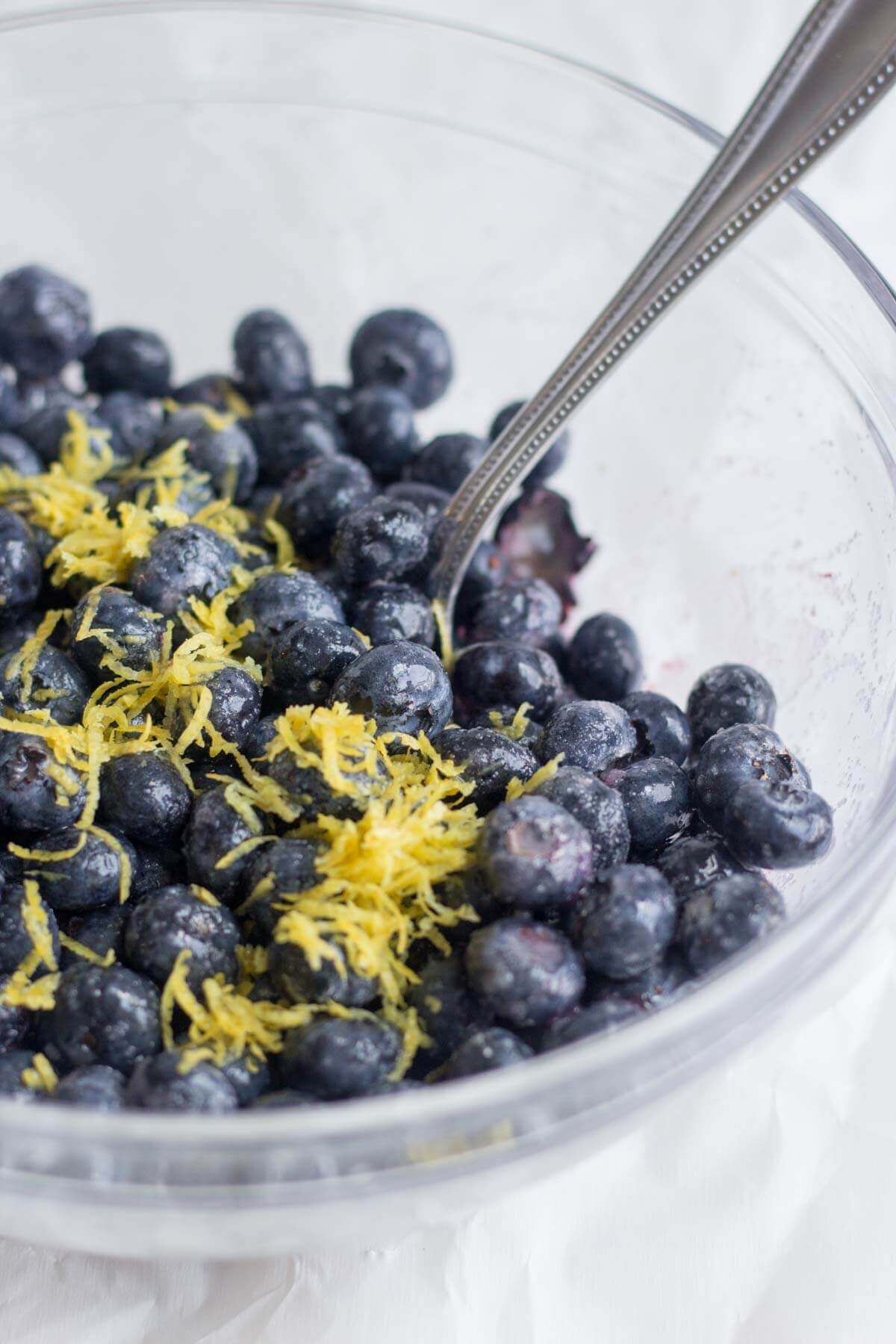 fresh blueberries in a bowl with sugar and lemon zest