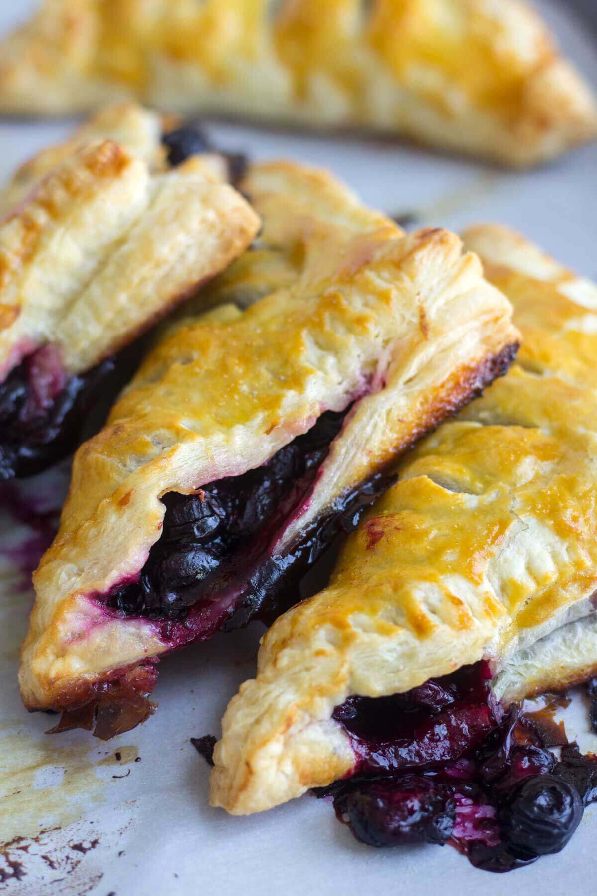 three blueberry turnovers stacked next to each other