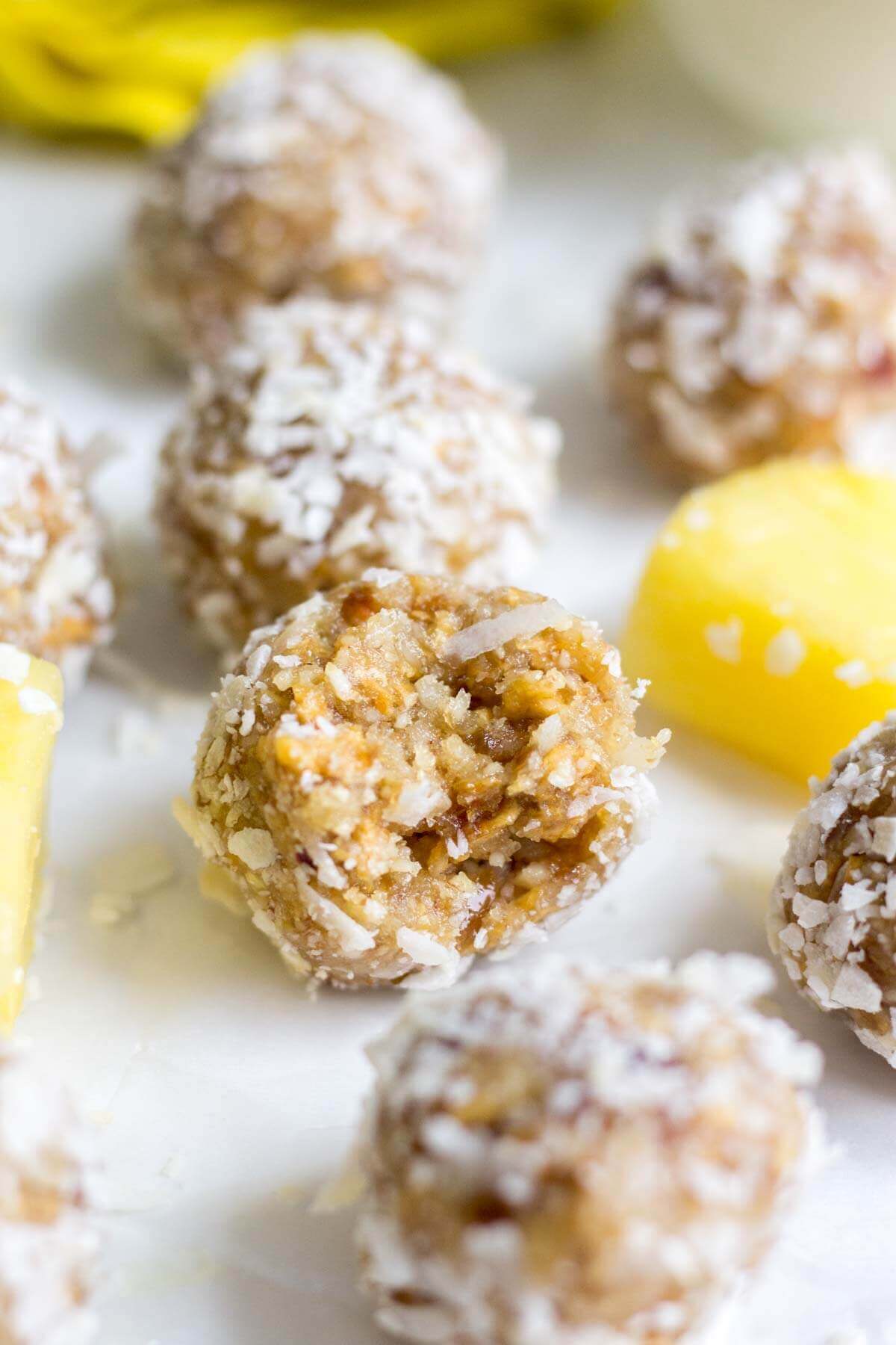 pina colada energy bites on a baking sheet with a bite taken out of one