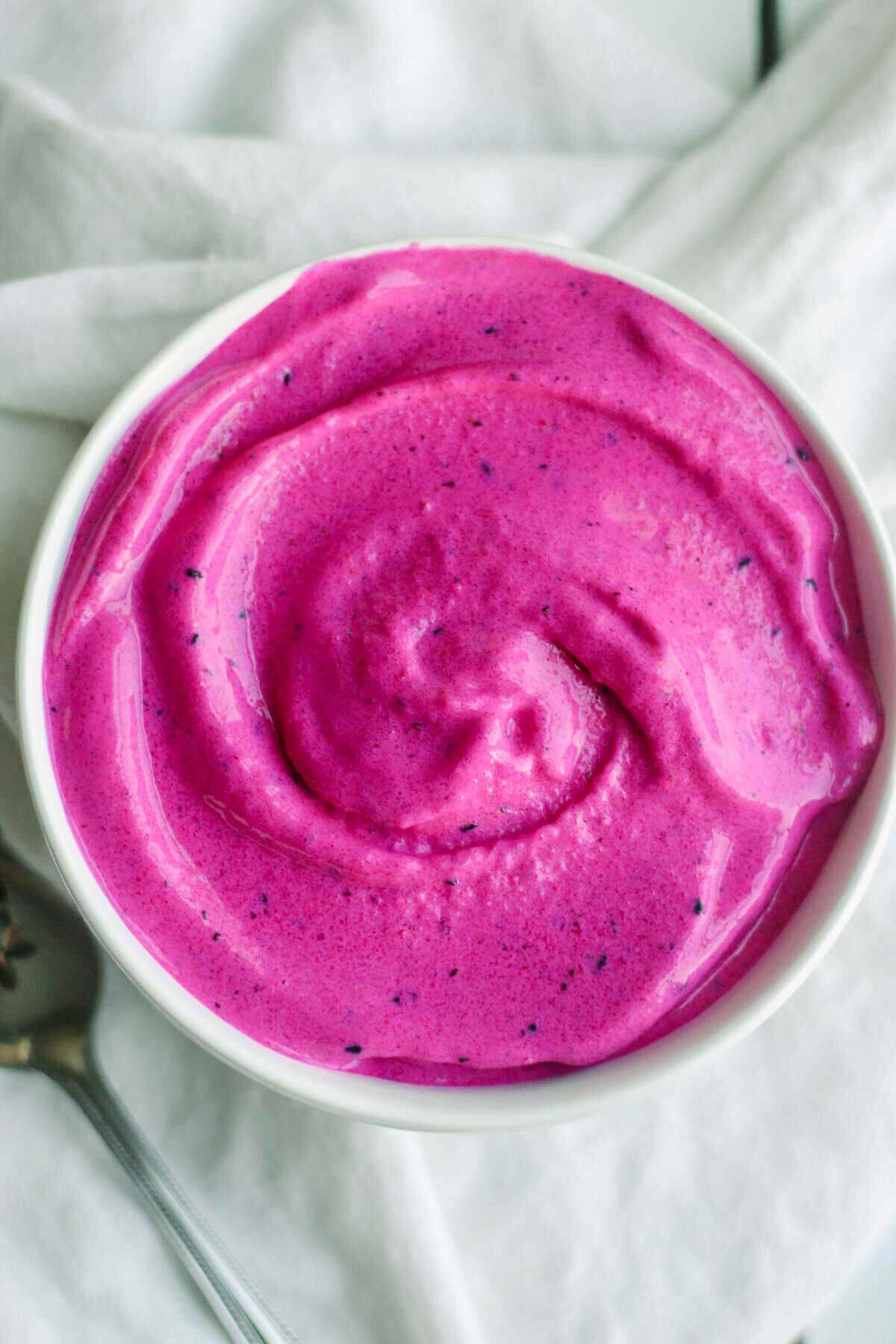 pitaya bowl recipe swirled in a white bowl with a spoon