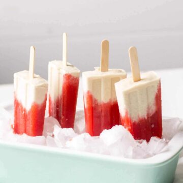 These paleo, gluten free and vegan popsicles are an easy summer/spring recipe to brighten up our day. The creamy layer is made with raw cashews and coconut milk and the strawberry layer is made with fresh strawberries and lemon. Both layers are sweetened slightly with pure maple syrup for a cool and sweet snack or dessert.