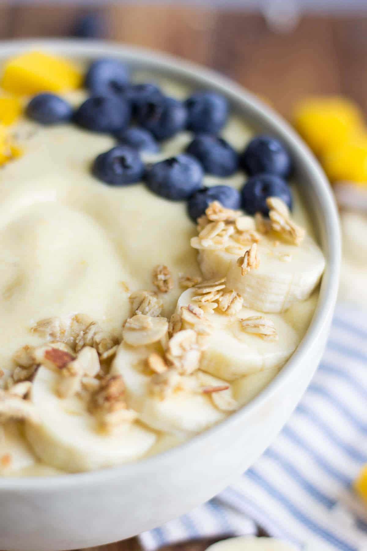 fresh sliced banana with granola on top of a banana coconut smoothie