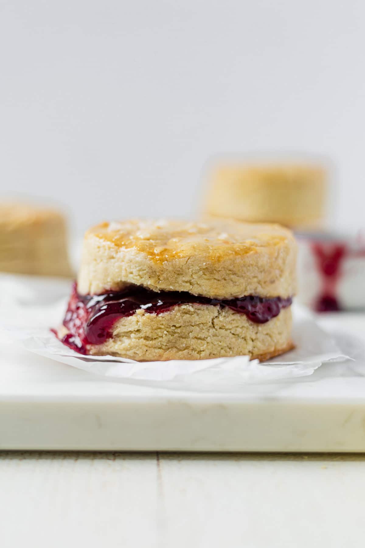 a flaky golden brown vegan biscuits filled with strawberry jam that's oozing out of the side