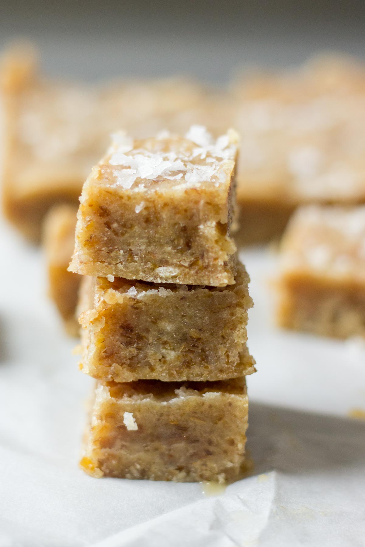 You will be amazed by these healthy caramels! They're made with tahini, dates and coconut oil. Blend all of the ingredients in the food process and freeze in a loaf pan. Sprinkle with sea salt and dunk them in dark chocolate. These easy healthy salted caramels will be your go to dessert recipe.