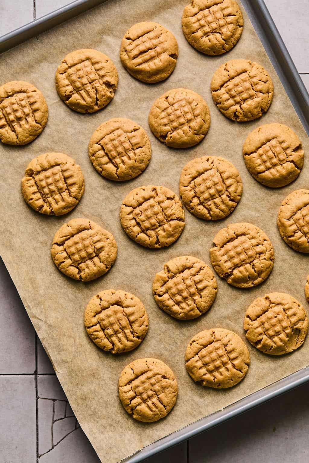 baked flourless peanut butter cookies cooling on a baking sheet.