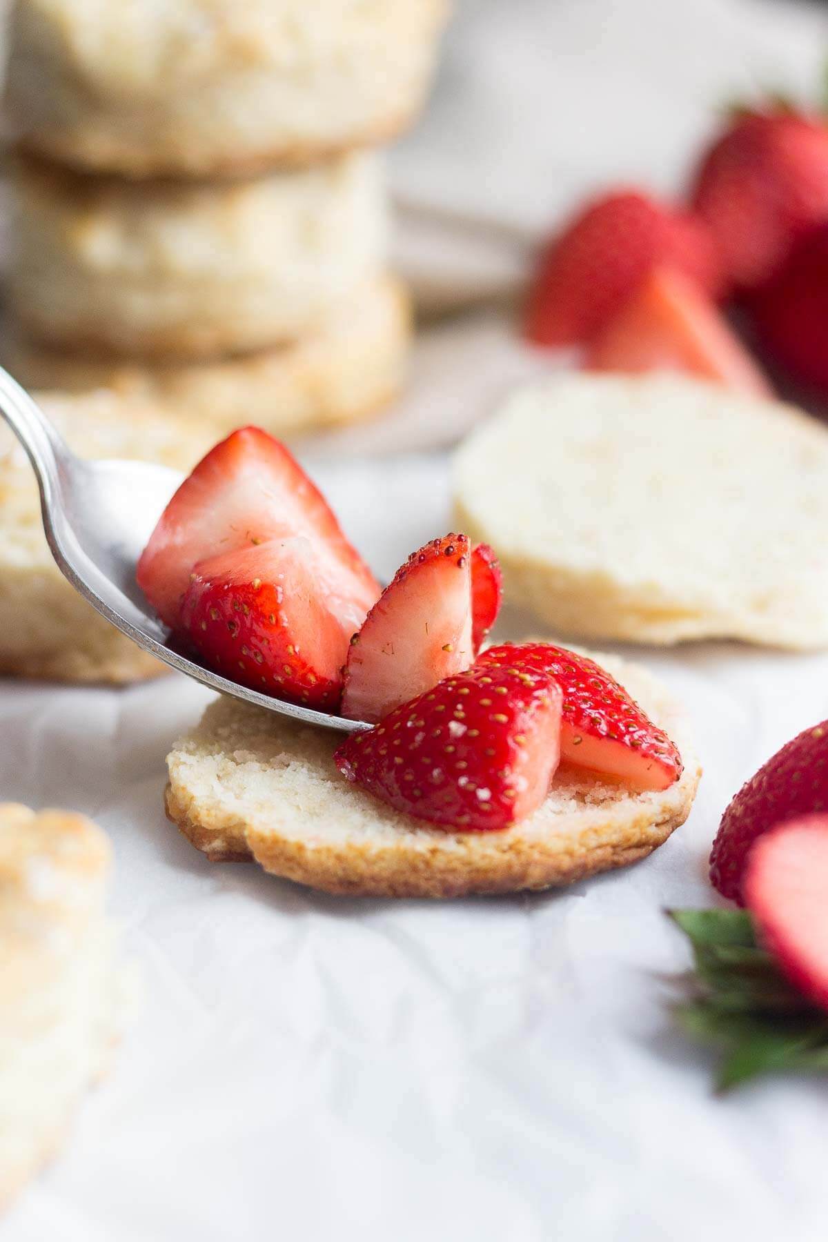 spoon placing the strawberries onto a Healthy strawberry shortcake