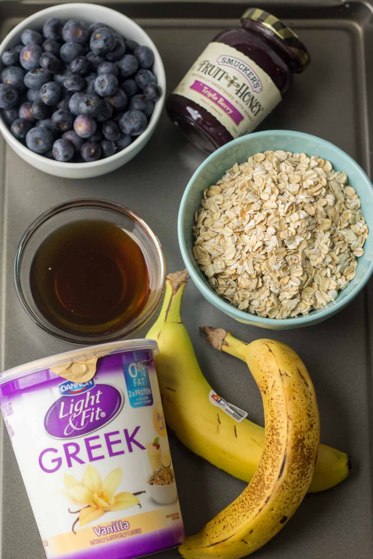 ingredients for triple berry blender muffins laid out on a cookie sheet