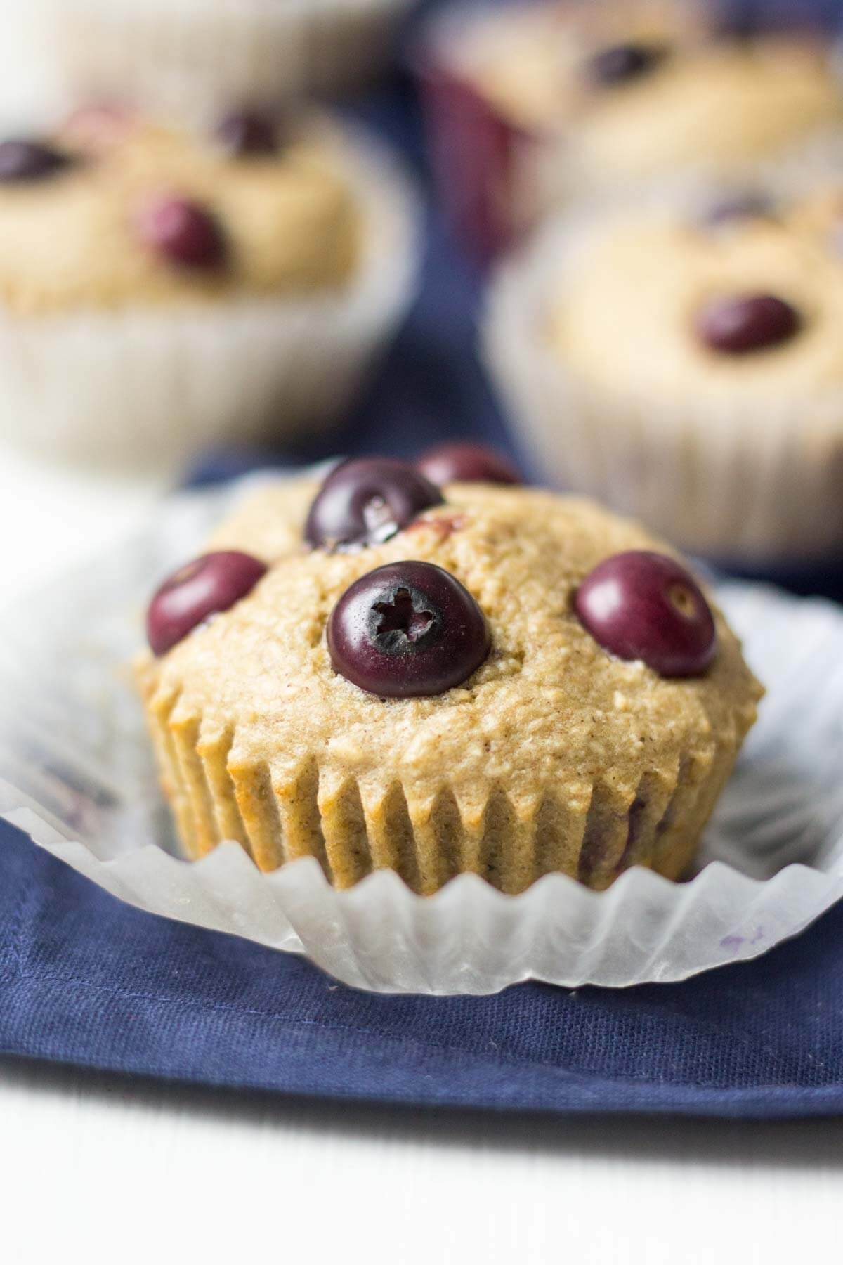 triple berry blender muffins cooling on a blue napkin