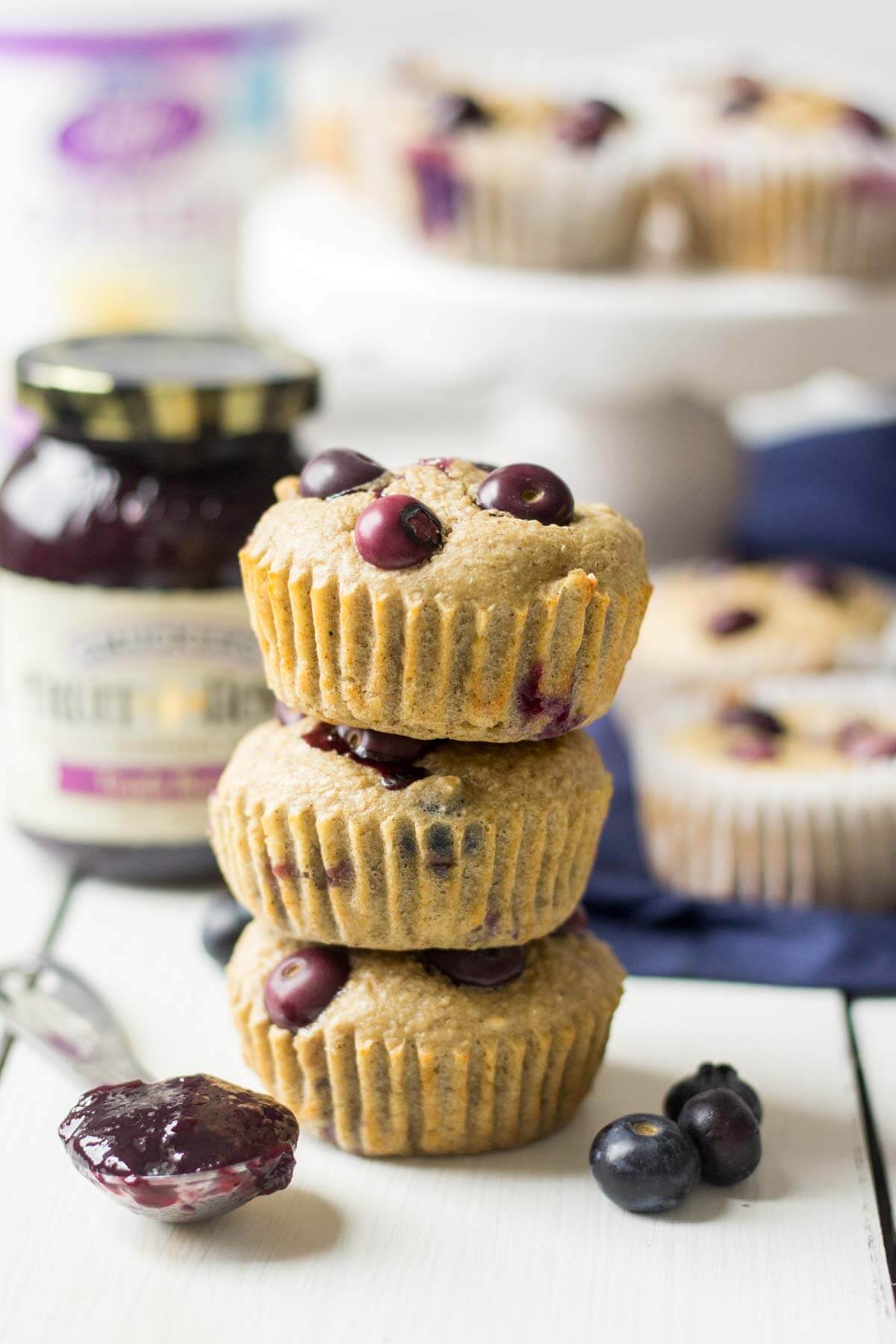 healthy blueberry muffin recipe stacked with a side of berry jelly