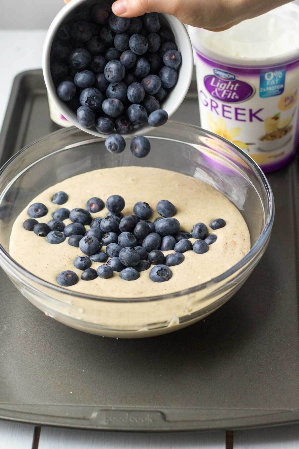 blueberries getting dumped into the batter for triple berry blender muffins