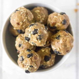 blueberry muffin energy bites stacked in a white bowl