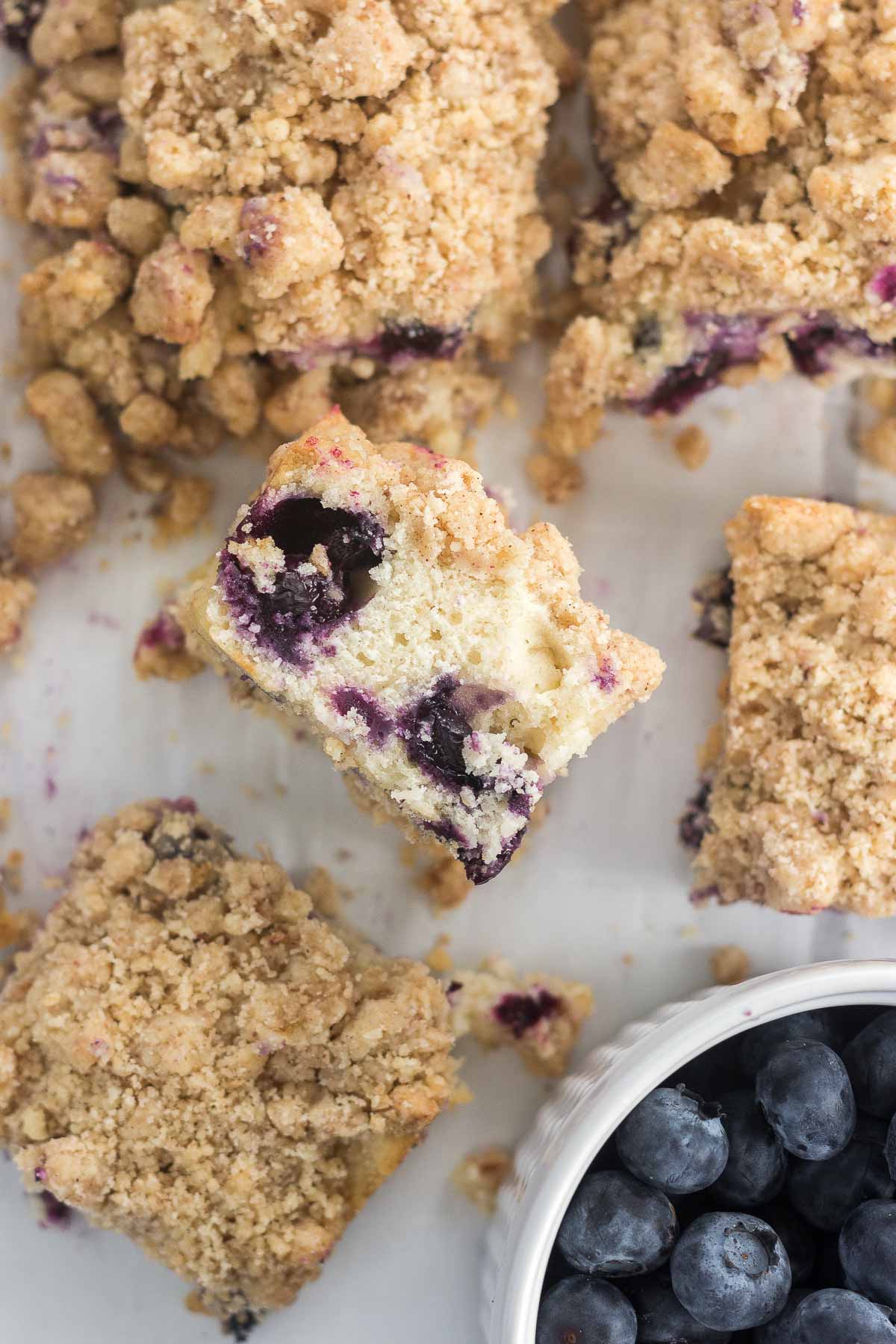 Brown Butter Blueberry Coffee cake slices on a counter with blueberries