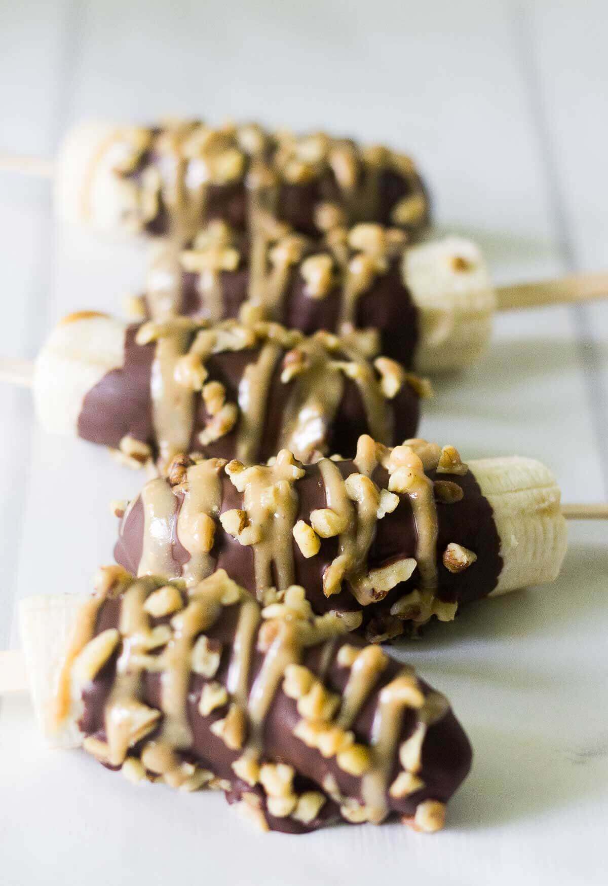 paleo frozen bananas laying in a row on a cookie sheet