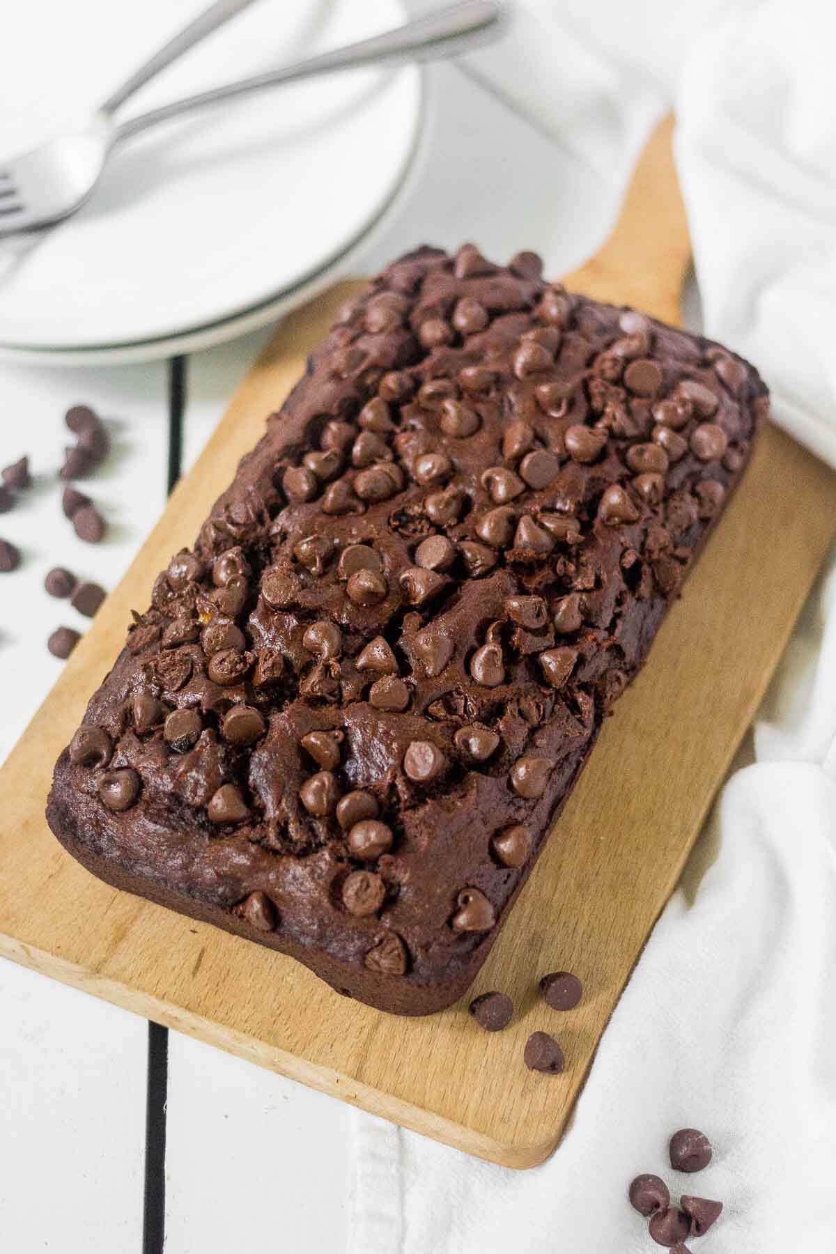 loaf of healthy chocolate chip banana bread on a wooden cutting board