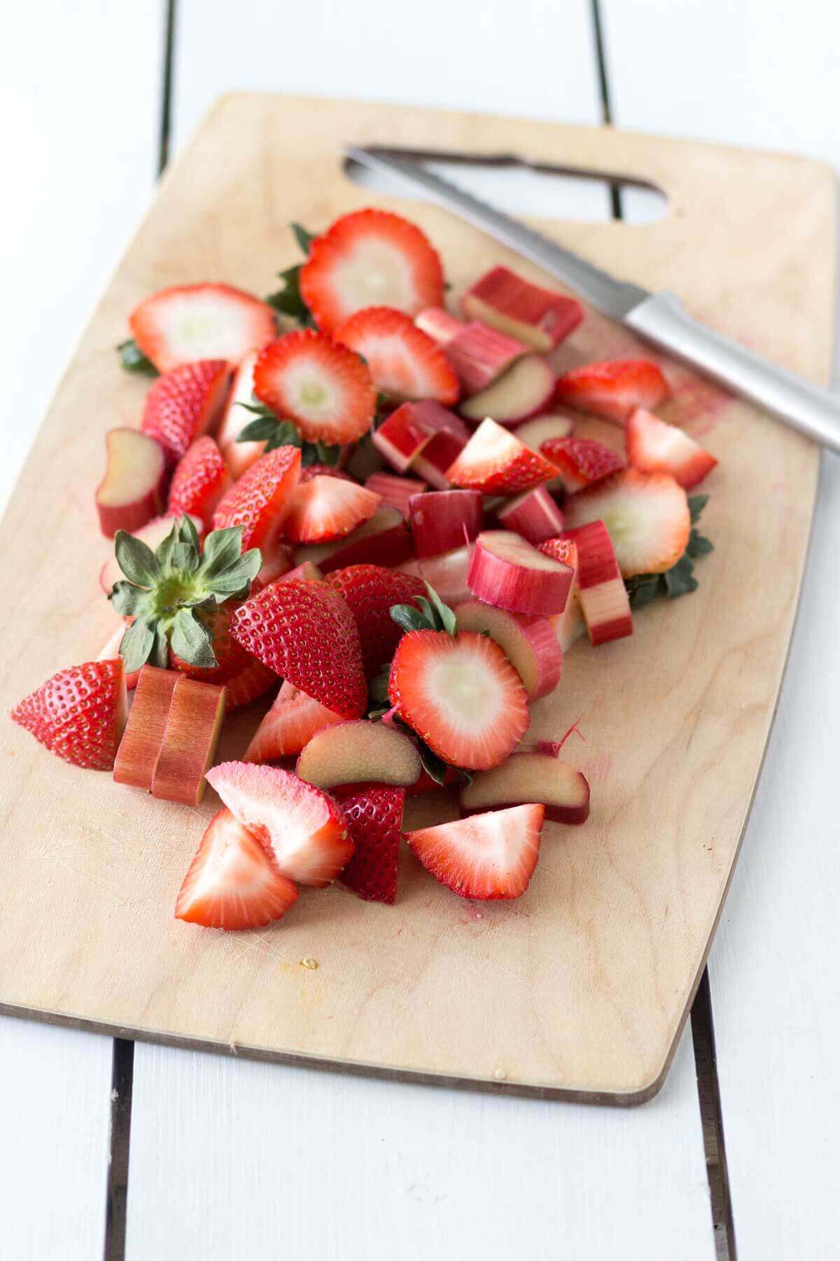 sliced strawberries on a cutting board with a knife