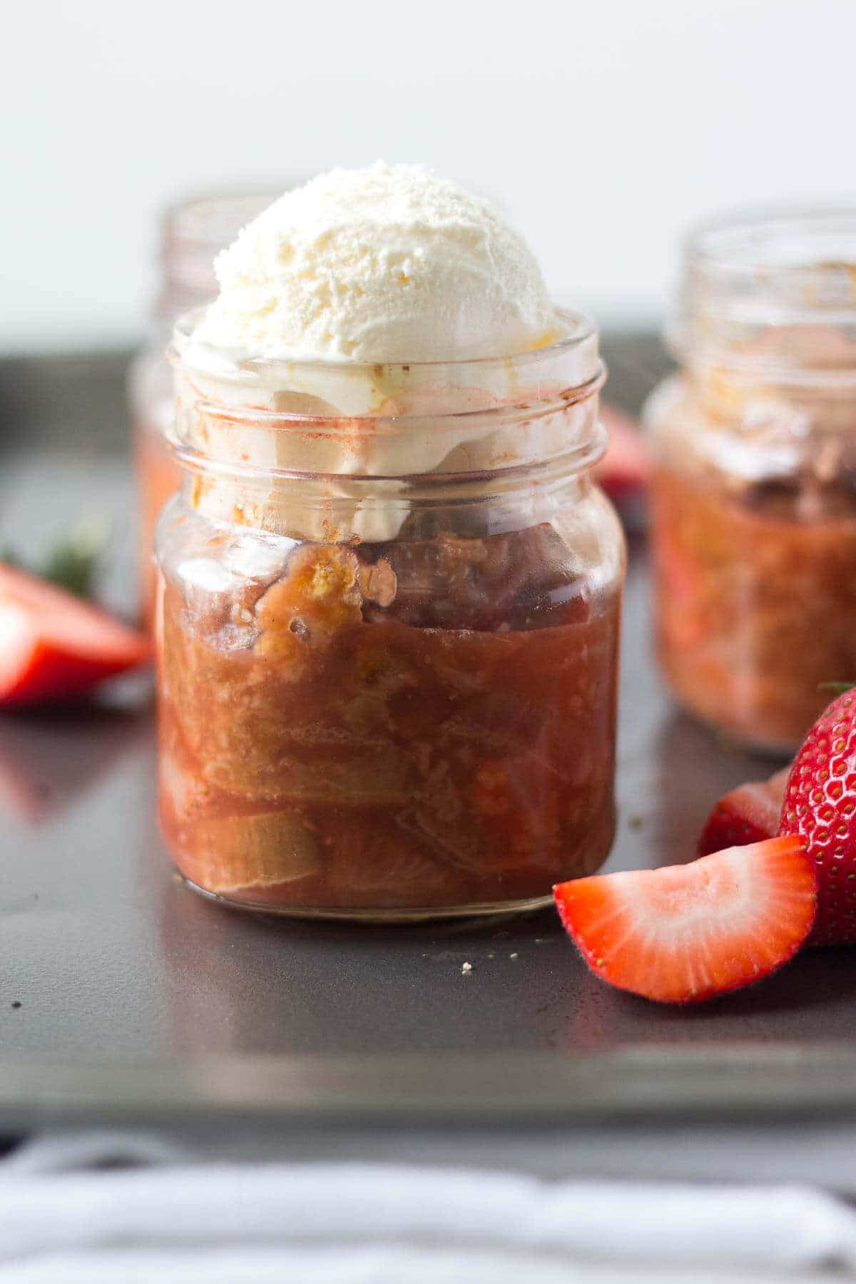 strawberry rhubarb crisp with a scoop of vanilla ice cream on top