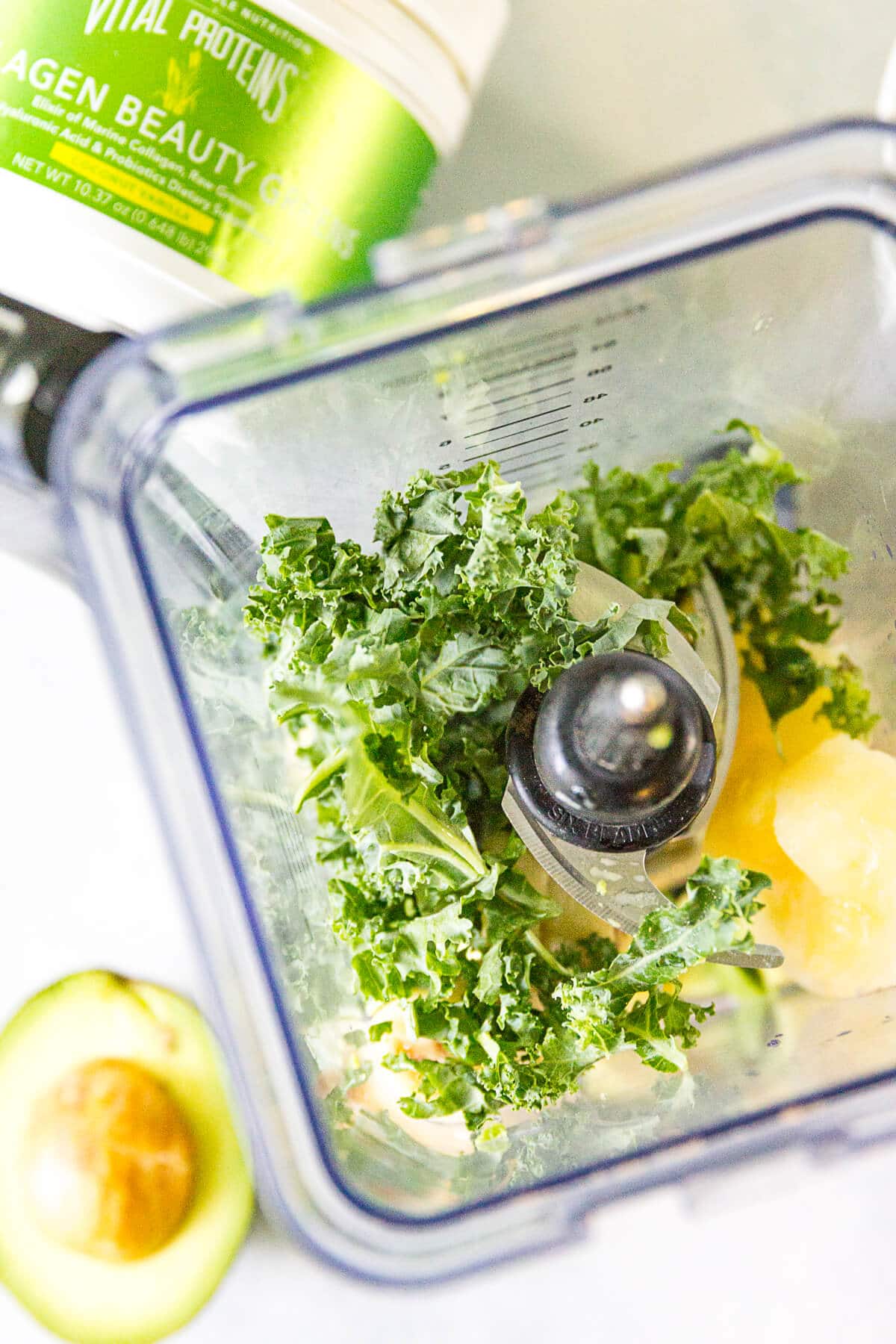 green smoothie bowl ingredients in a blender on a white counter