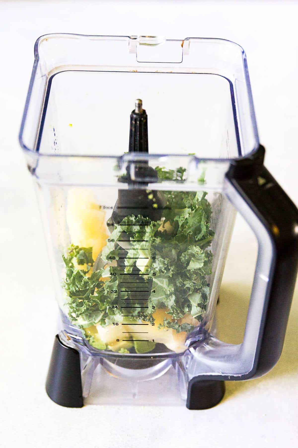 green smoothie bowl ingredients in a ninja blender on a white countertop